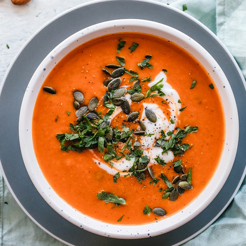 Kom tomatensoep met pompoenpitten en peterselie