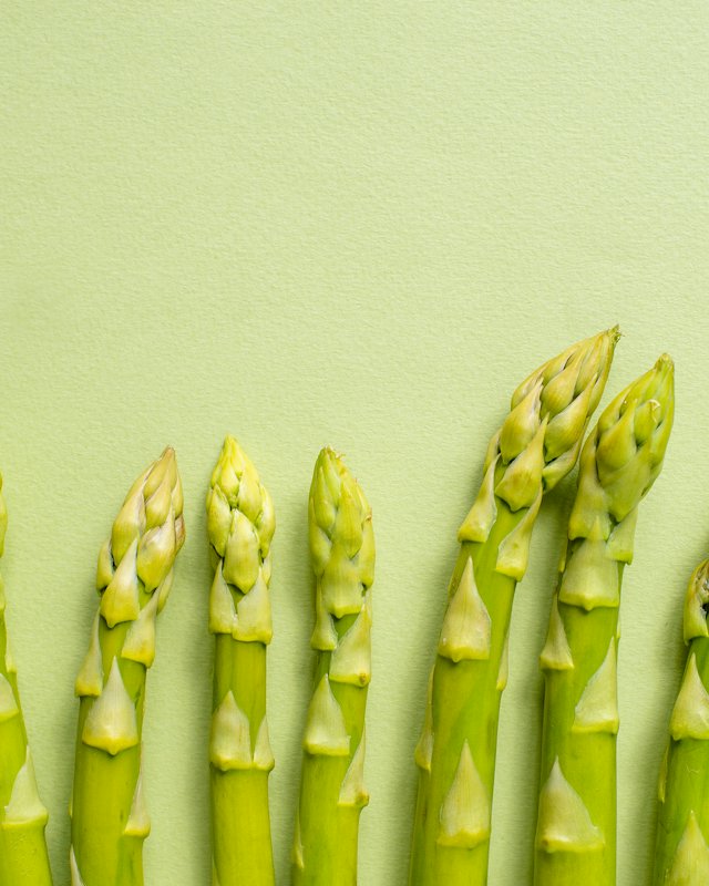 Groene asperges op een lichtgroene ondergrond